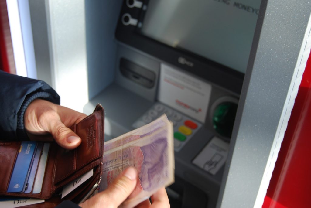 Money being put in to a wallet at an ATM